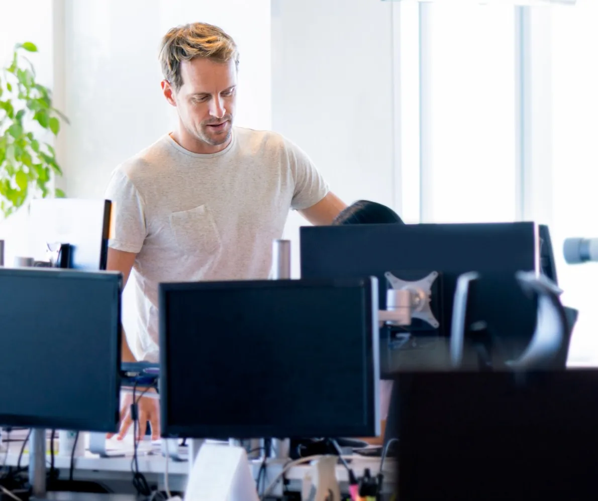 Andre at his desk in a busy open-plan office