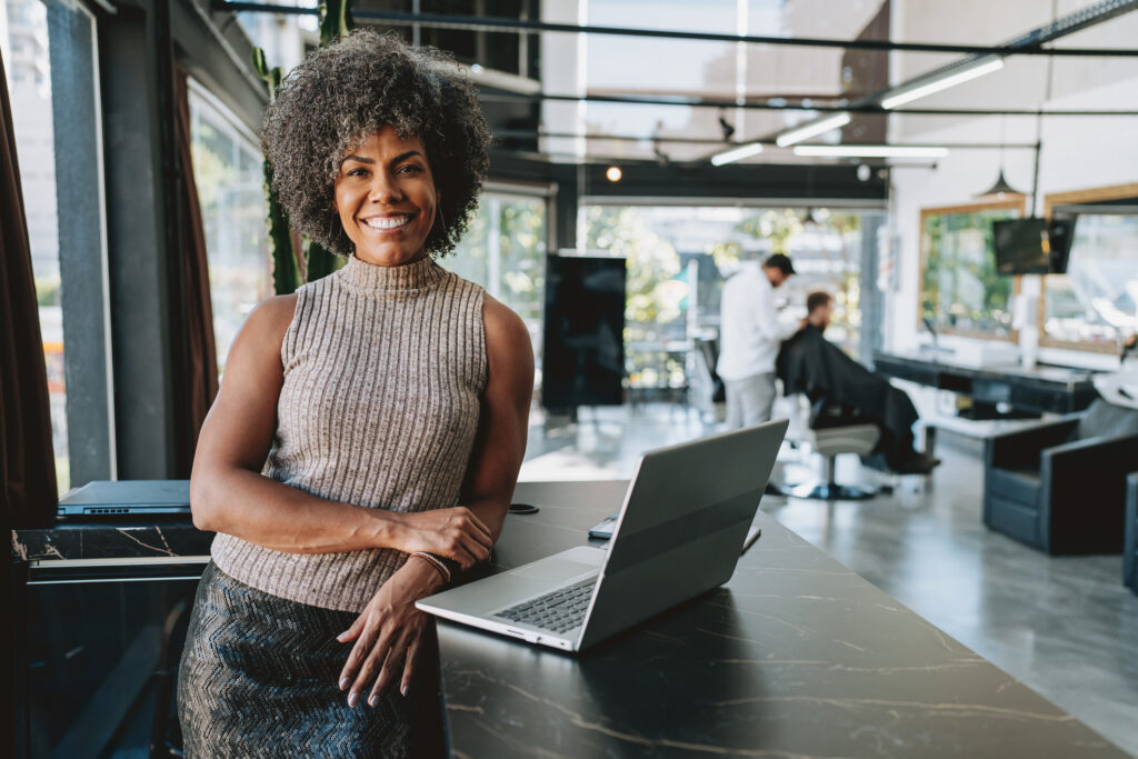 Woman in front of a laptop in a Barber shop