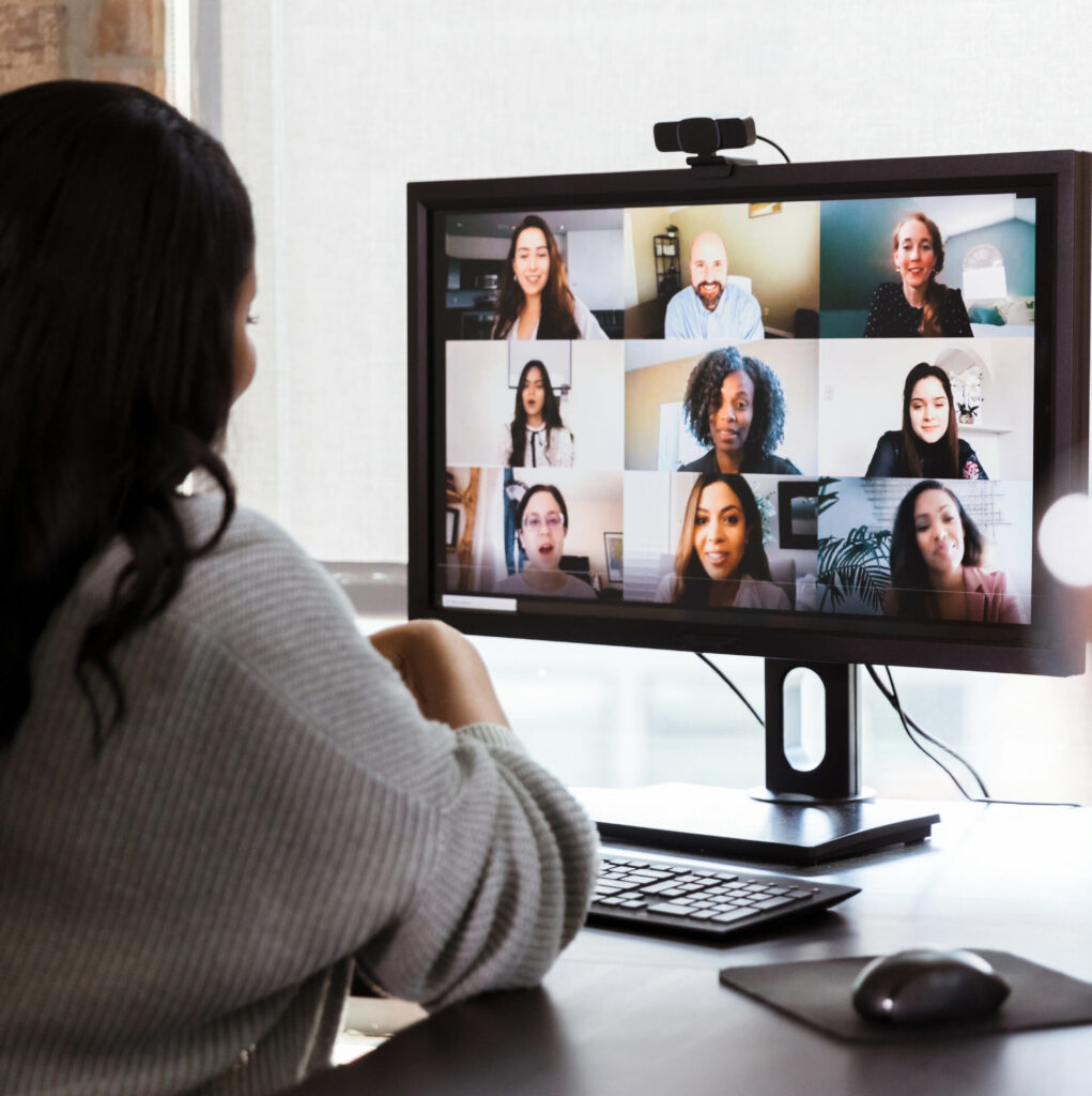 virtual meeting - person in front of computer monitor with several other pictures of people