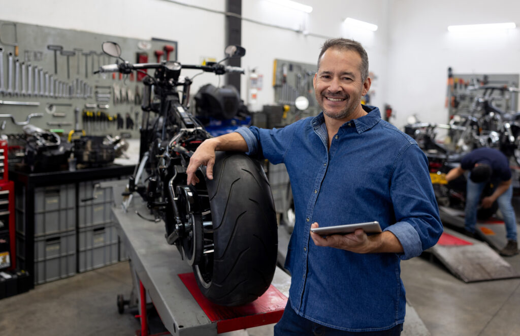 Business owner smiling at a motorcycle repair shop