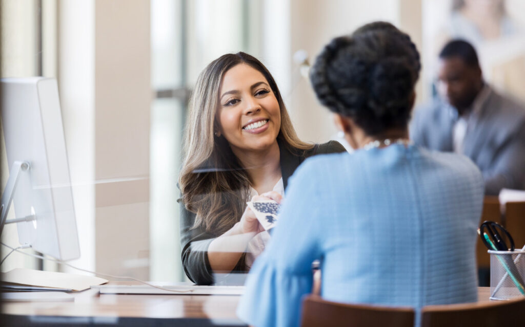 woman assisting another woman to open a business checking account