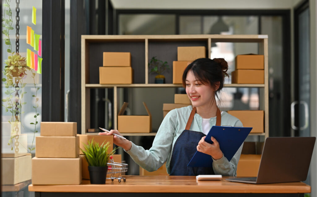 Woman with clipboard surrounded by lots of boxes