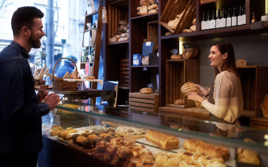 Man talking to a woman at a bakery