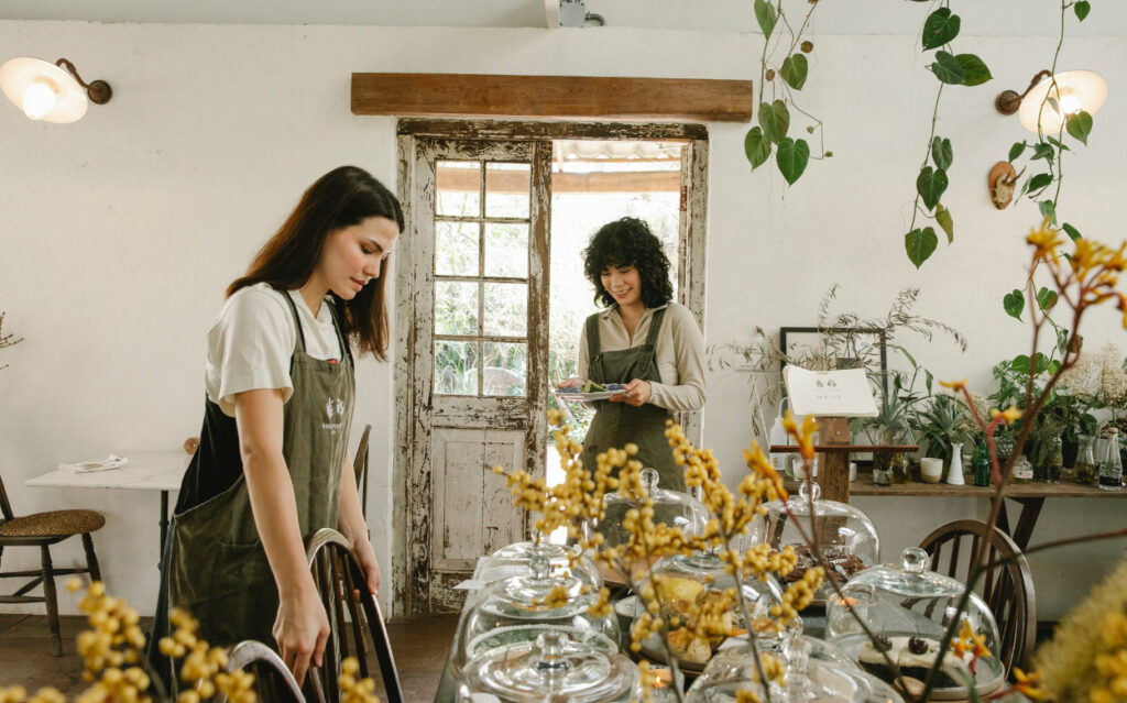 two women in aprons setting a large beautiful table