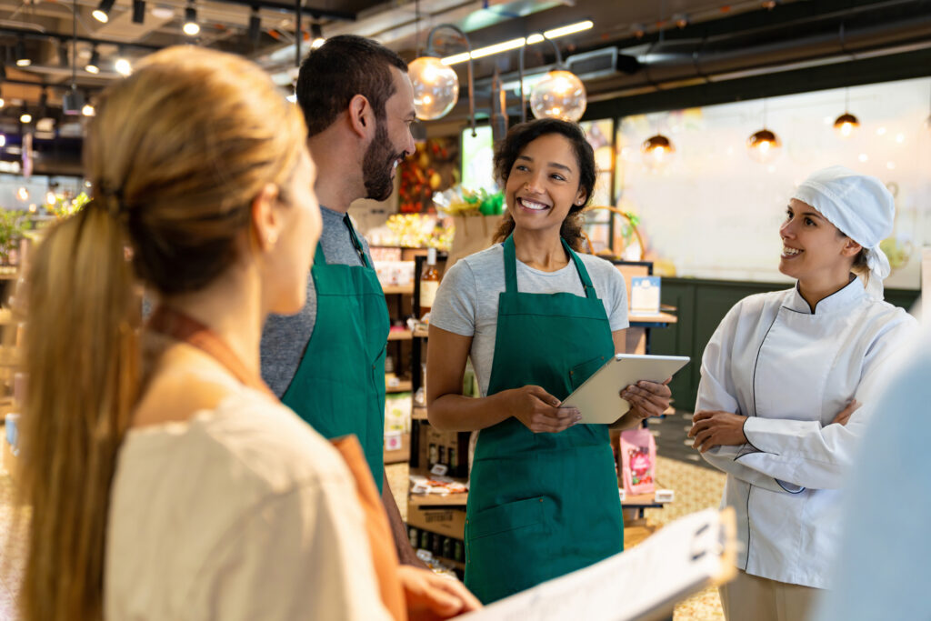 Happy group of employees in a training session at the supermarket