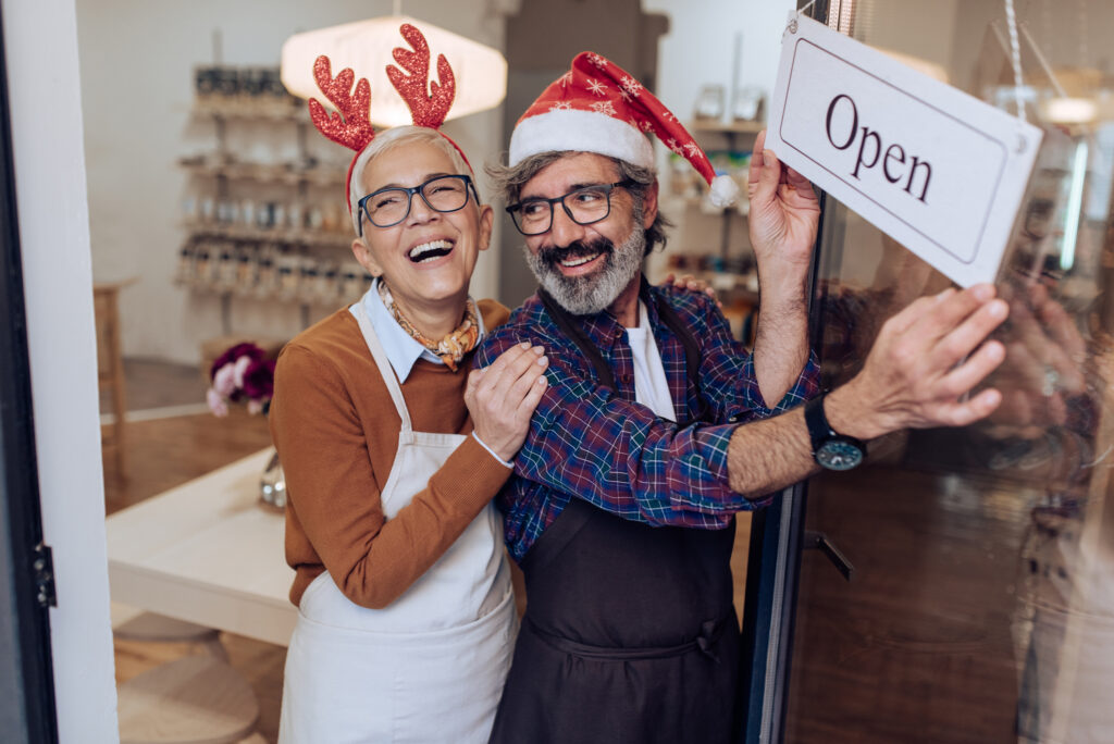 Mature couple opening their shop and celebrating Christmas