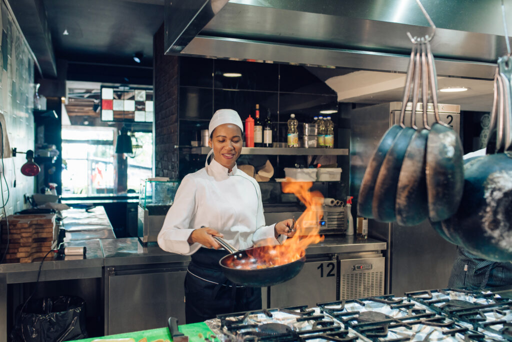 Female chef is preparing a flambé specialty