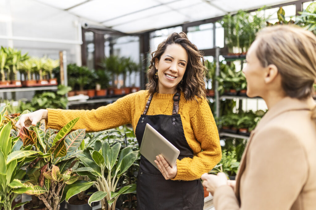 Smiling woman at a garden center talking with an employee