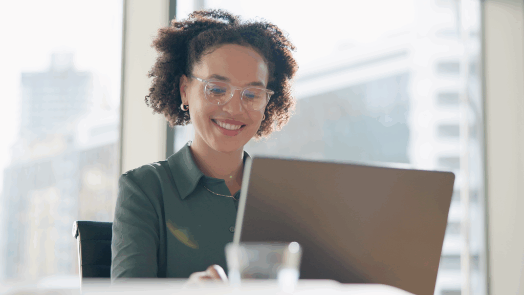 Woman smiling typing on laptop