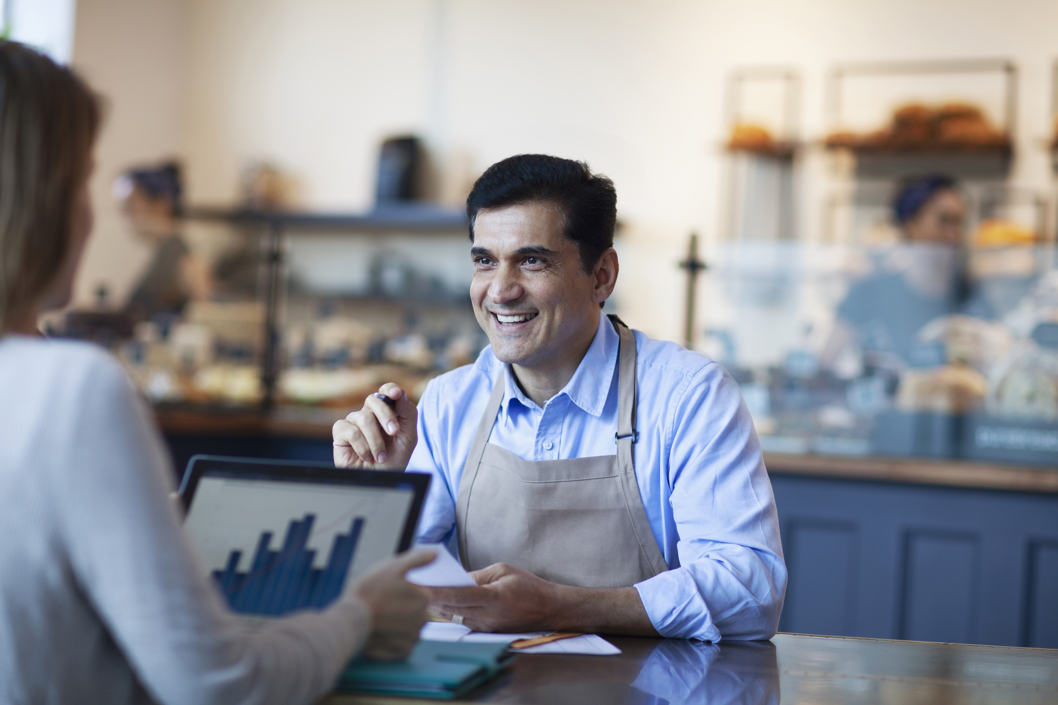 Male investor talking to women and man owners of a bakery cafe