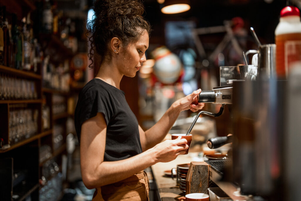 Young Barista Preparing Fresh Coffee in Cozy Cafe