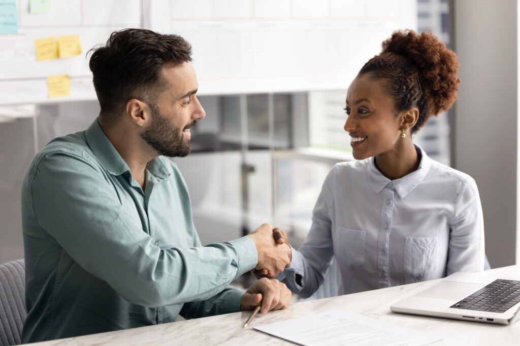 Happy man and woman shaking hands like closing a deal