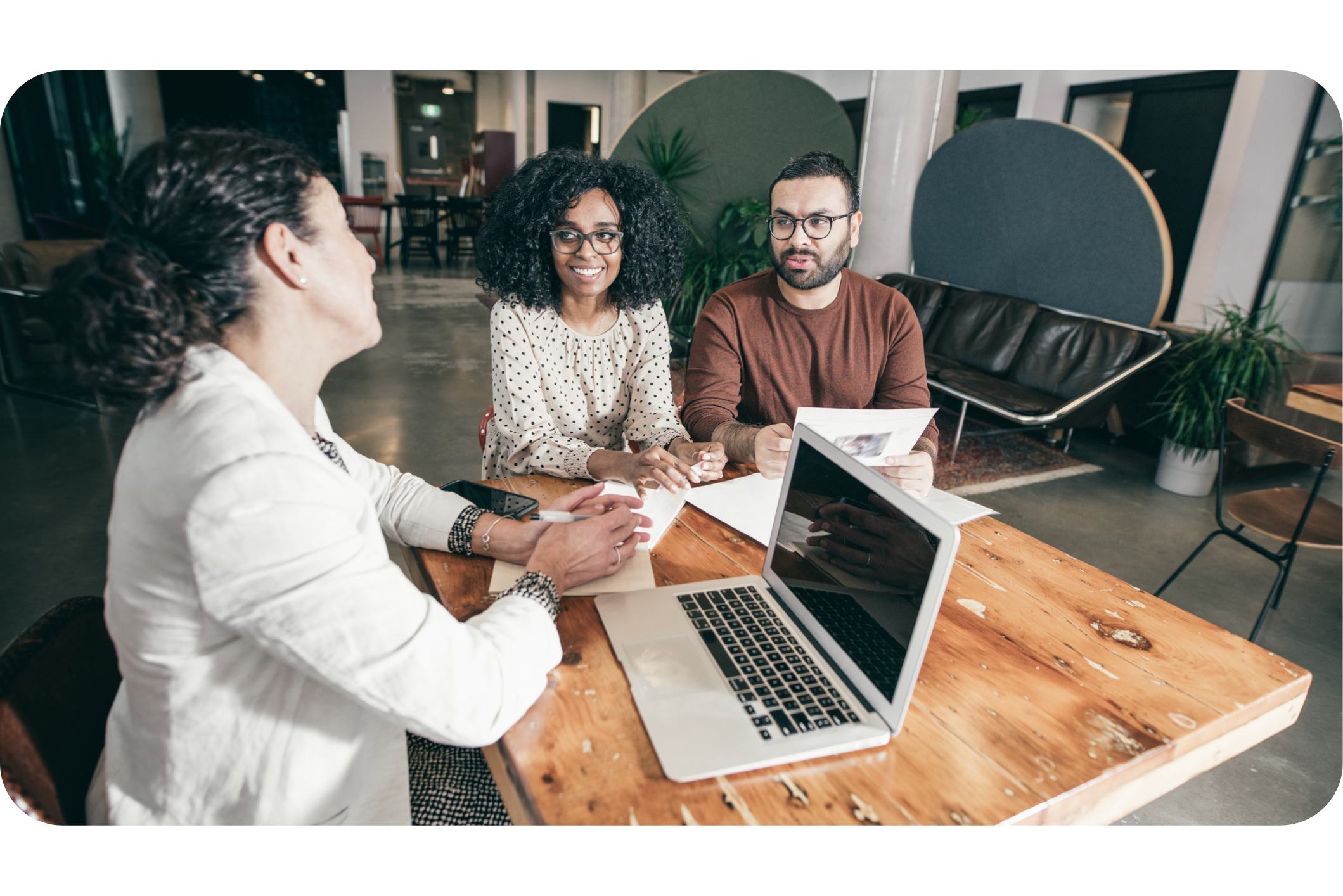 Two managers at work in the business office talking to an advisor