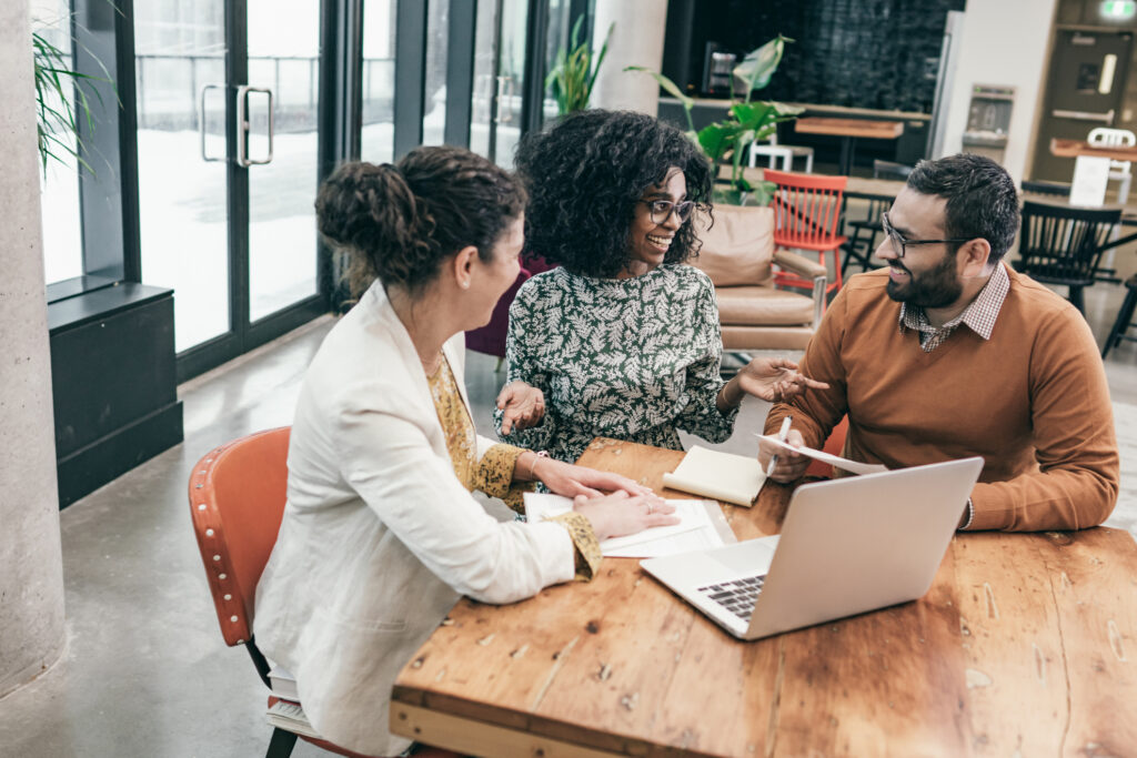 Two managers at work in the business office talking to an advisor