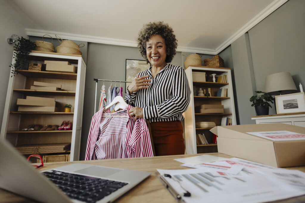 Female small business owner smiling cheerfully while standing in her shop.