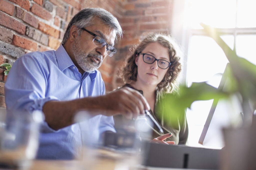 senior designer architect showing model to colleague in office