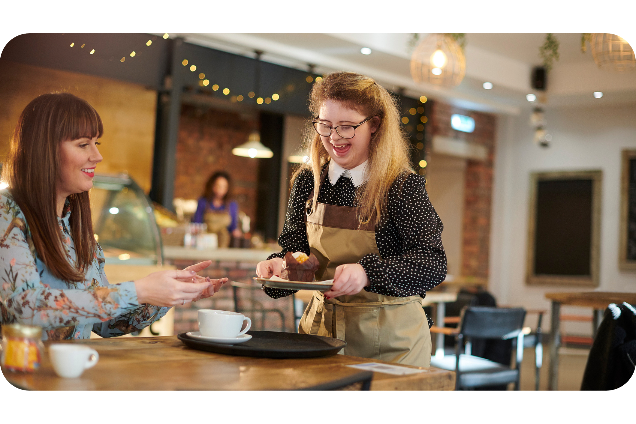 female working, giving a muffin to a new customer