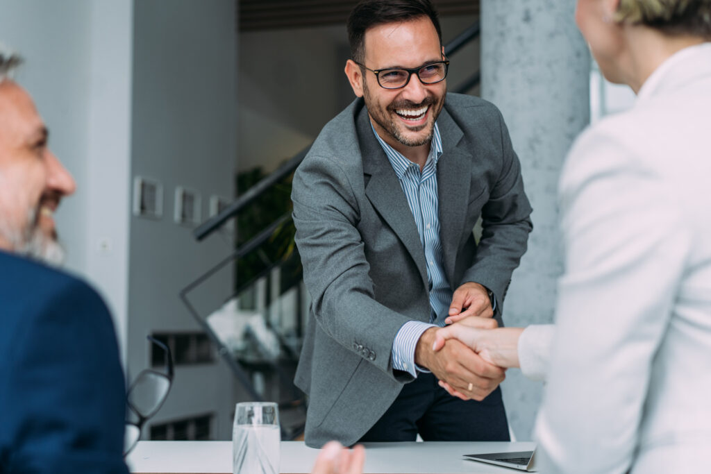 Business people handshaking across the table during a meeting