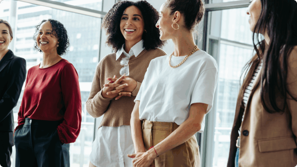 Women in a meeting smiling and looking at each other