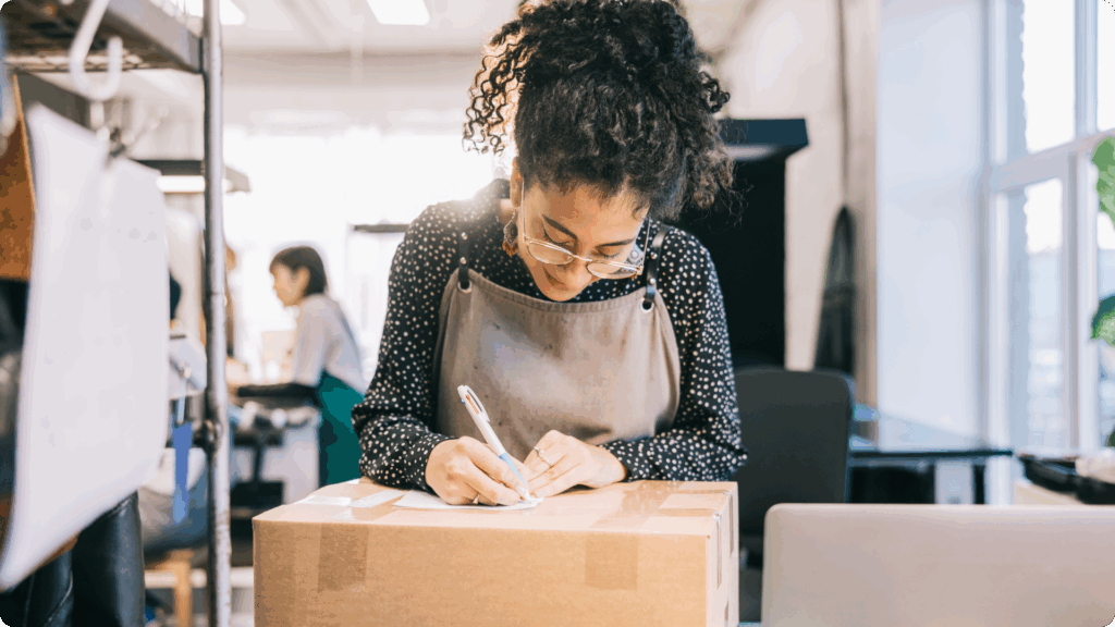 Small business owner signing package for customer