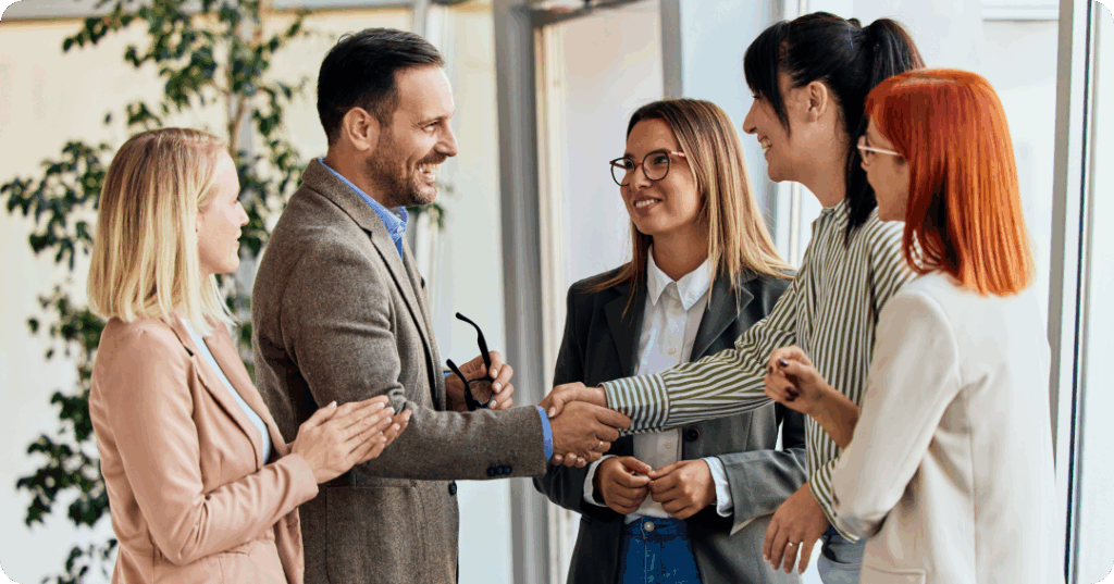 business partners standing and shaking hands with one another