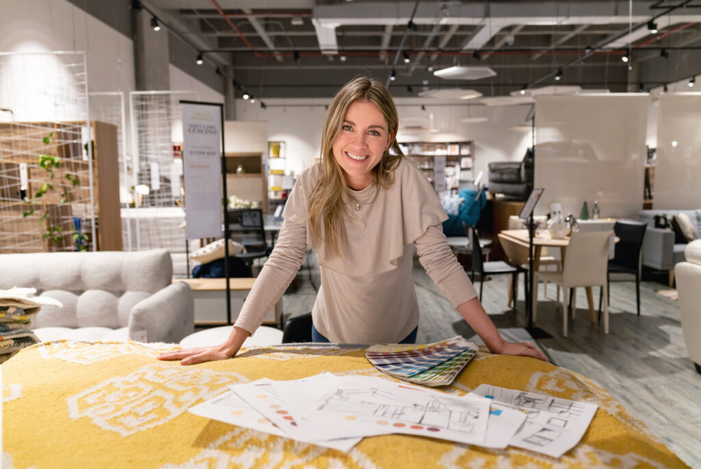 Portrait of a happy interior designer working on a home design at a furniture store and looking at the camera smiling